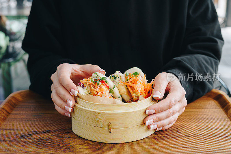 在街市上吃蔬菜馒头的妇女