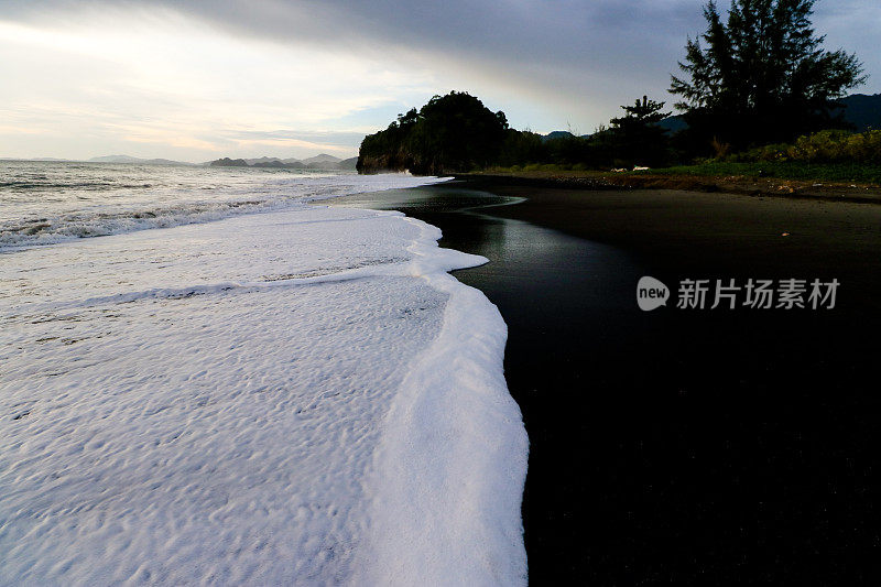 白色的海浪和黑色的沙滩