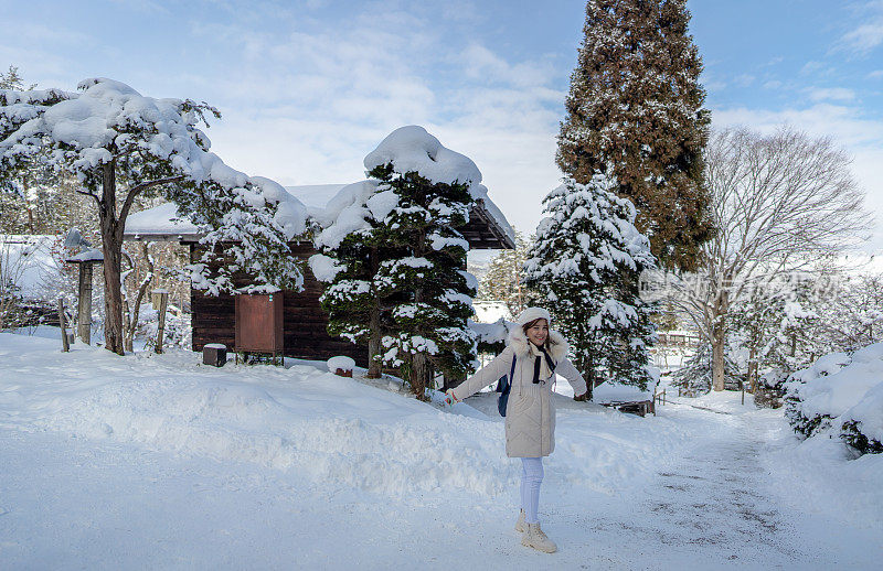 美丽的女子游客享受他们的日本之旅在雪的冬天