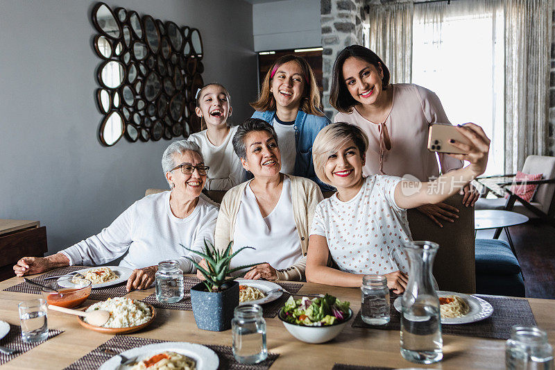 拉丁美洲，多代女性家庭聚餐时摆姿势自拍