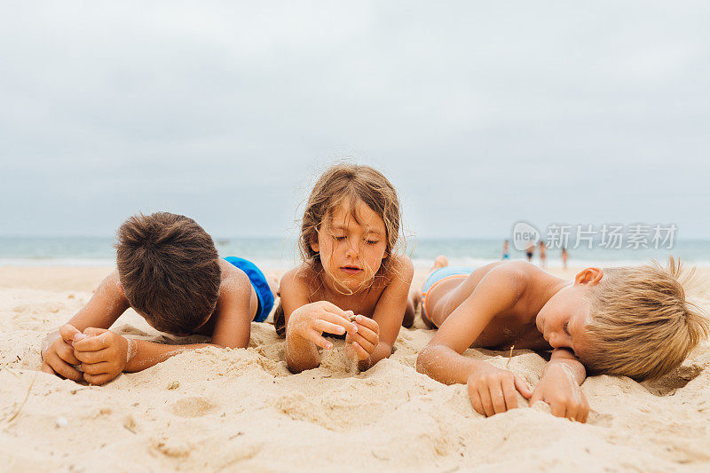 无聊的孩子们躺在沙滩上