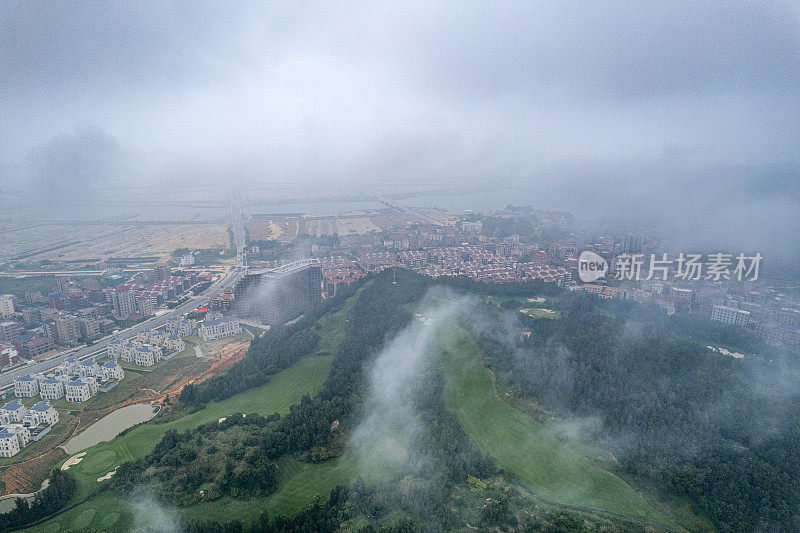 通过雾航拍拍摄的高尔夫球场