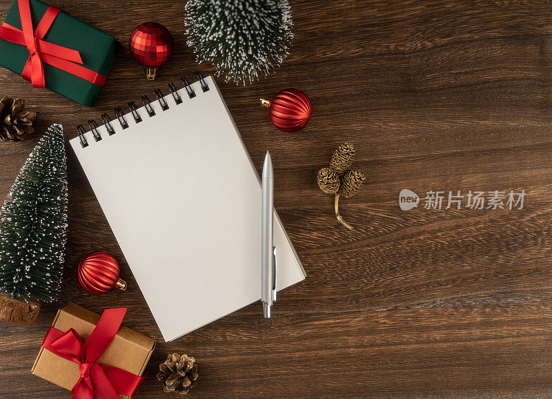 节日装饰和笔记本在木桌上，从上面，圣诞规划的概念。