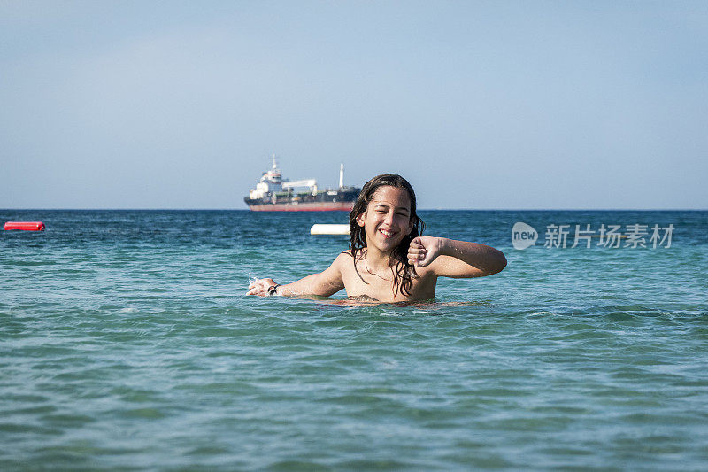 他用手在海里泼水。一个夏天的早晨。忒涅多斯岛。爱琴海北部，12岁的帅哥。长头发的