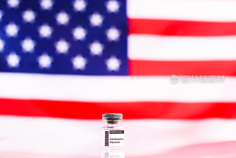 密封的透明小瓶，装着预防冠状病毒引起的新冠肺炎的新疫苗，背景是美国国旗，没有重点。