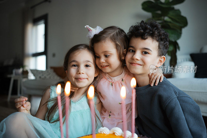 过生日的小孩在家里吹灭蛋糕上的蜡烛