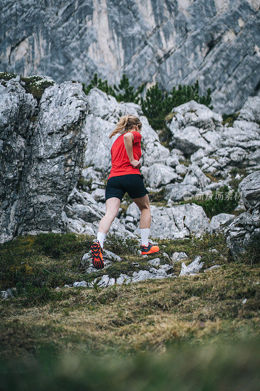 女越野跑运动员沿着山路跳跃