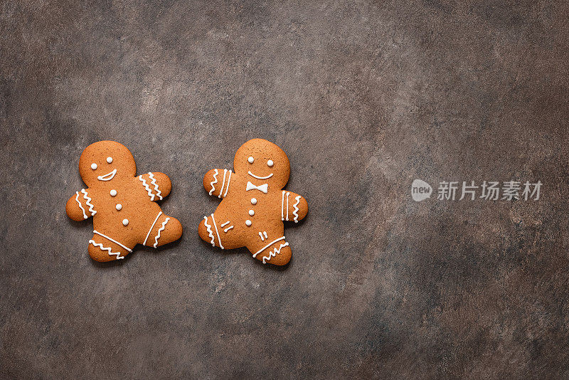 两个姜饼人在黑暗的乡村背景上平躺着。