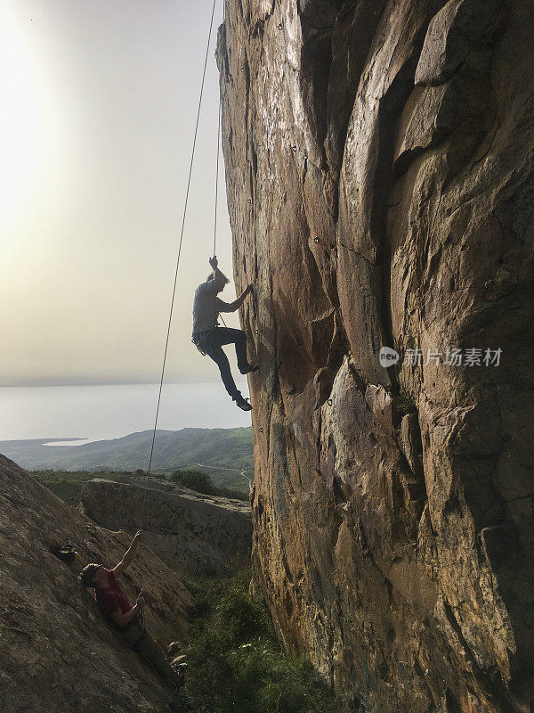 成熟的男人用绳子爬悬崖