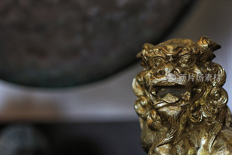 金色亚洲狮子雕像与龚在背景浅DOF