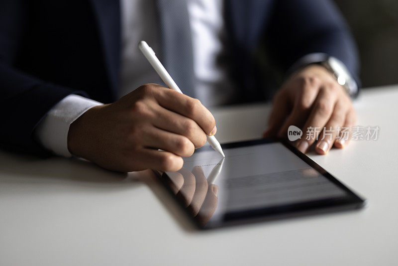 商人用触控笔在平板电脑上签署数字合同