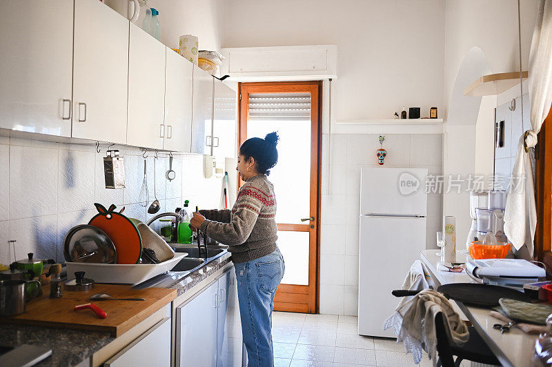 家庭主妇在厨房水槽里洗碗