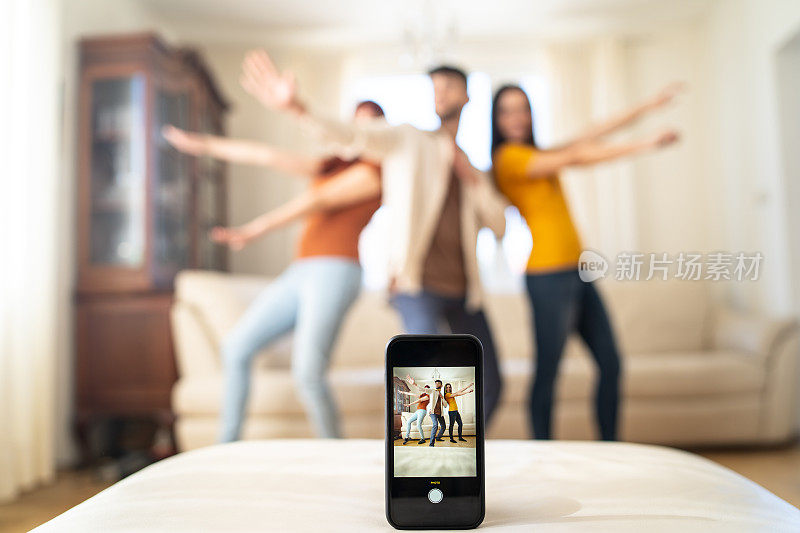 三个人在后台跳舞，手机屏幕记录下了他们的舞蹈