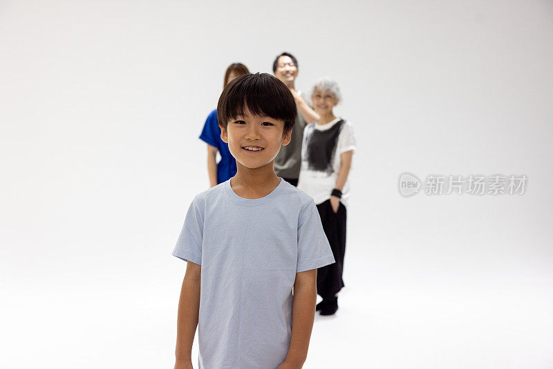 小男孩站在照相馆的家人面前