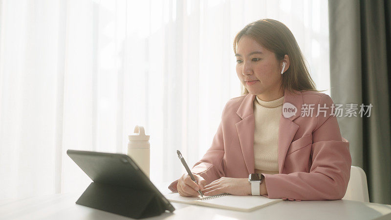 女人一边学习一边记笔记。