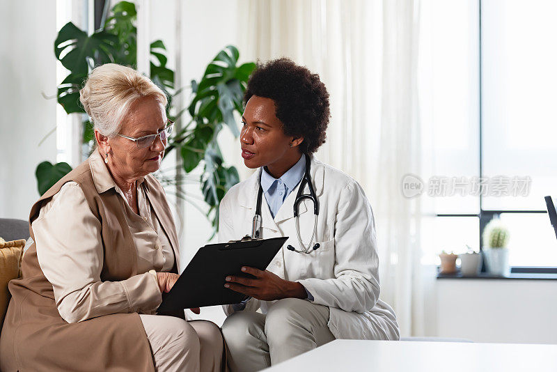 专科医生在诊所给病人咨询。一位女医生正在和一位老年女病人谈话。