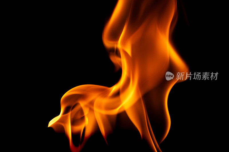 黑色背景上的炽热火焰。黑暗中美丽的火焰。燃烧的火焰和烟雾。