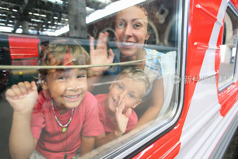 母亲和孩子们从火车窗口望出去