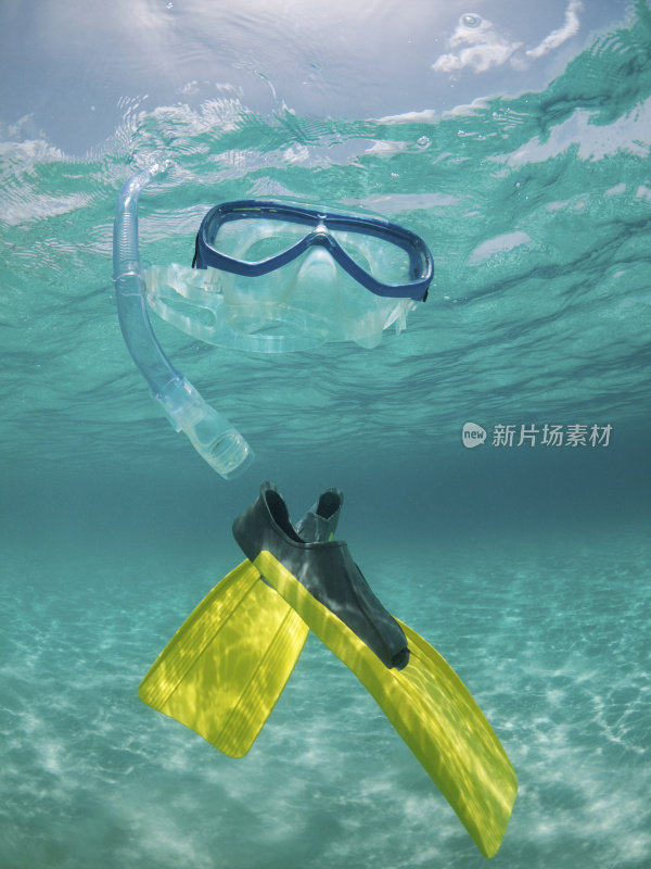 潜水面罩和脚蹼漂浮在热带水域