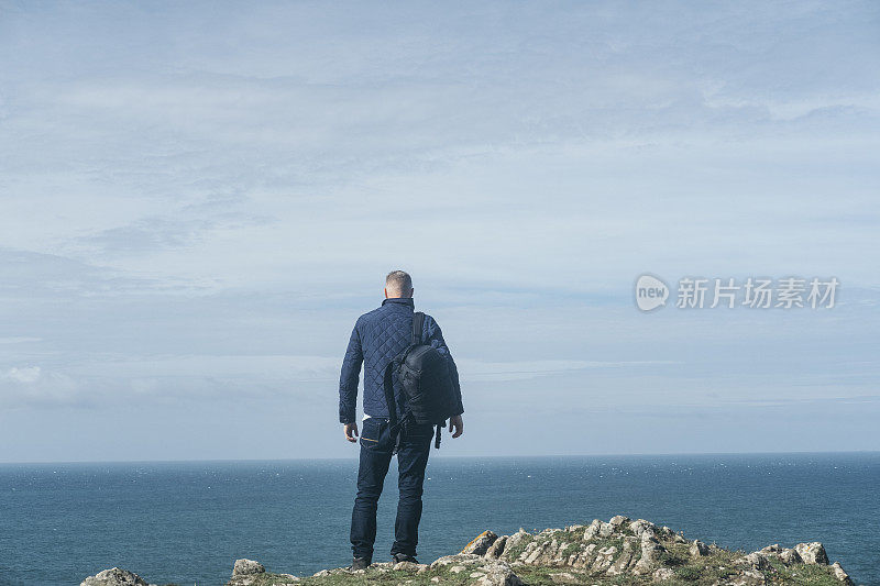 一名男子站在康沃尔金纳斯湾附近的悬崖边缘