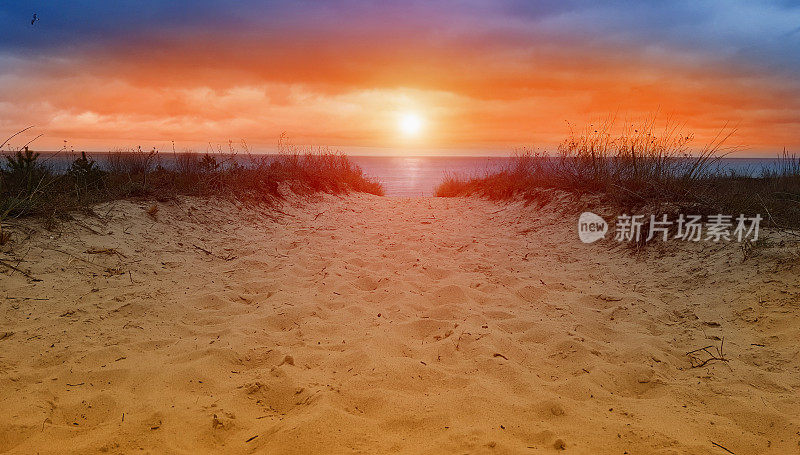 在日落或日出时，从沙丘到海洋，到海滩