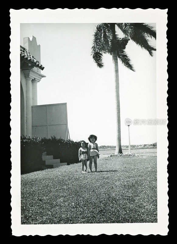 两个小孩在棕榈树旁玩耍