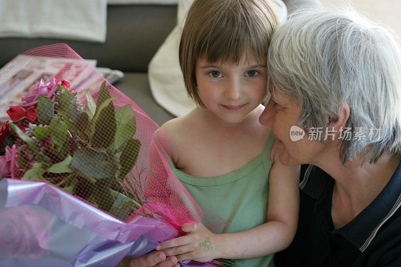 孩子送花束给年长妇女