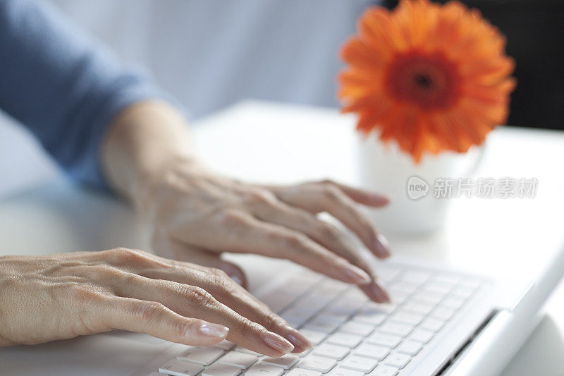 在白色笔记本电脑上打字的女人