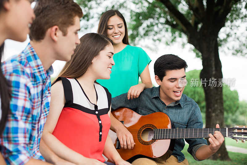 一群朋友坐在一起听朋友弹吉他