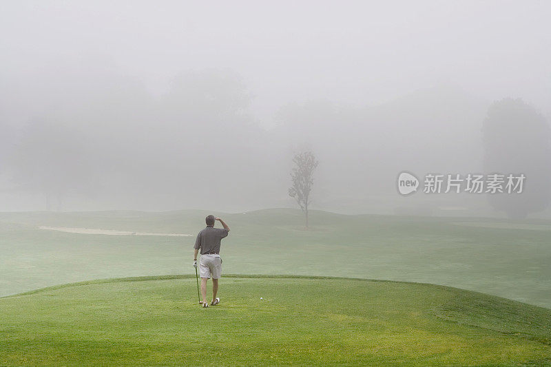 高尔夫球手在多雾的球场上能见度很低
