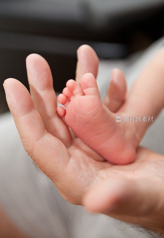 新生儿的脚在父亲的手里