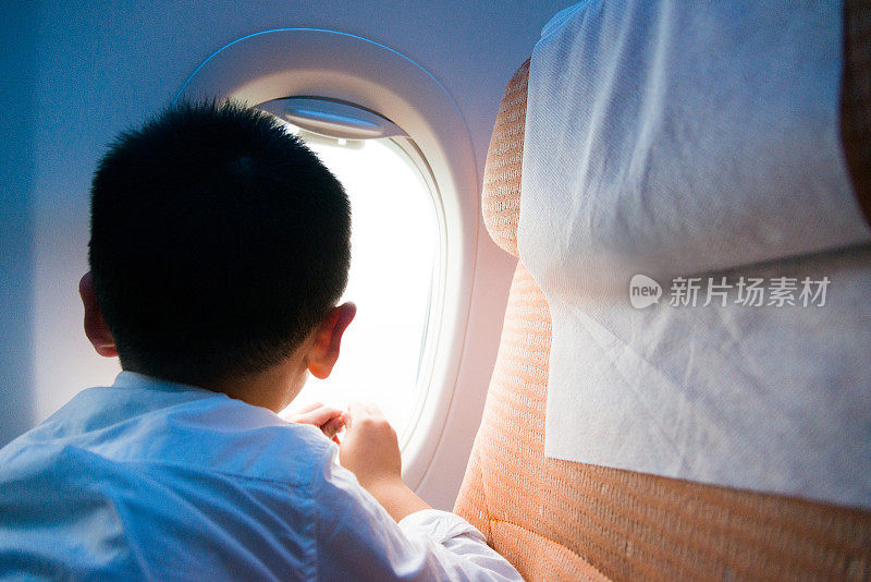 小男孩从飞机窗户往外看