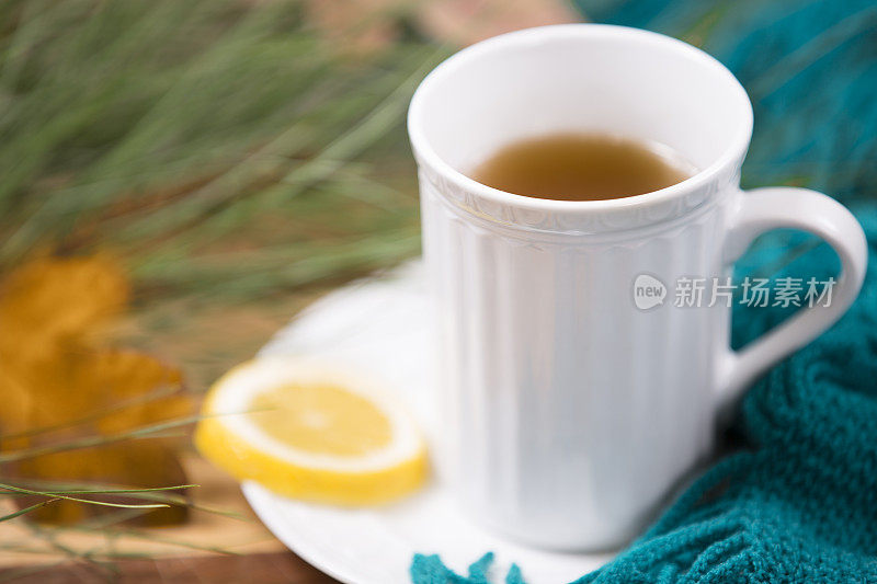 凉茶，白色杯子。冬松，绿围巾。木制的桌子。