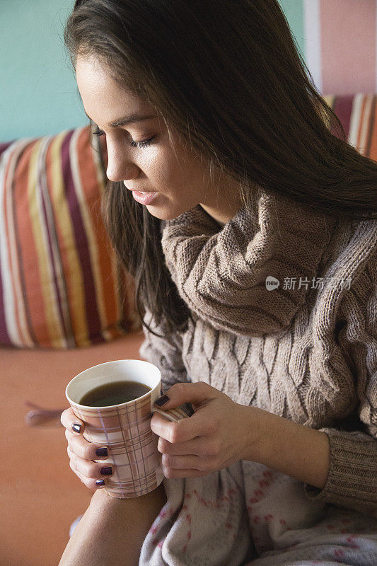 躺在床上拿着咖啡杯的女孩