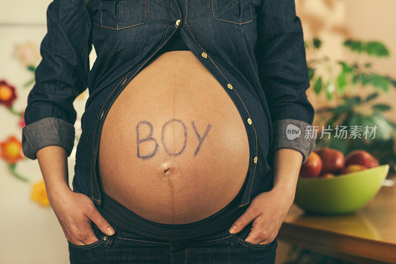 男孩写在孕妇的肚子上
