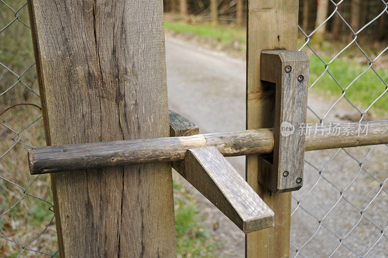 野生动物保护区围栏通道上的木锁。森林的路。