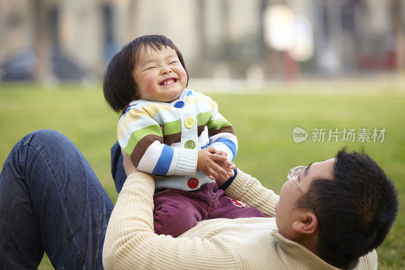 快乐的小女孩和她的父亲在户外玩