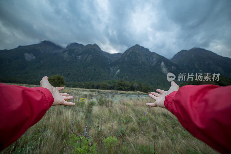 一个人向自然伸出双臂的个人视角