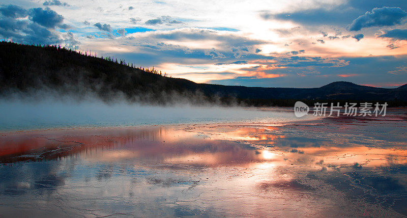 日落时在美国怀俄明州黄石国家公园的中途间歇泉盆地的大棱镜泉