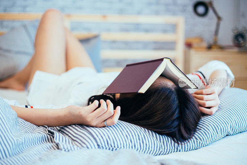 少女睡着了，而阅读的书在她的脸上