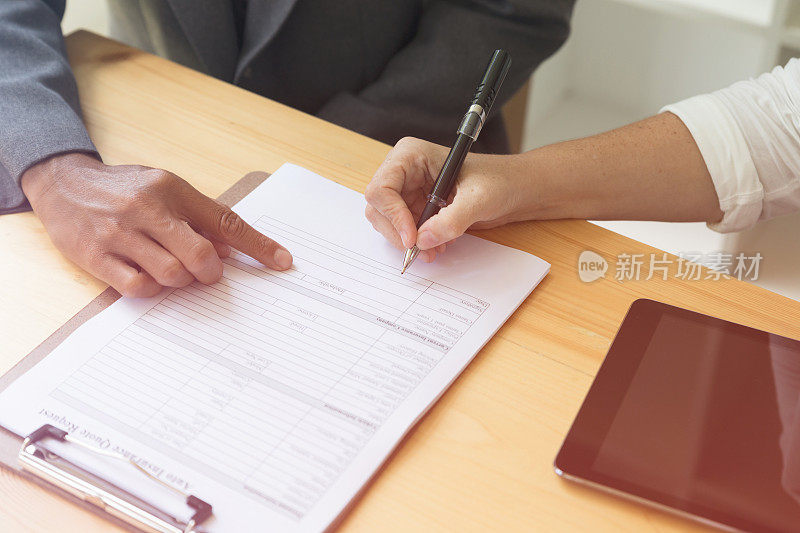 人手持圆珠笔在空白申请表纸上书写，填写空白文件模板，申请汽车保险