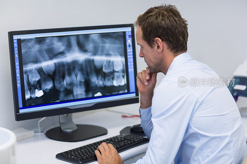 牙科医生在牙科诊所用电脑检查x光片