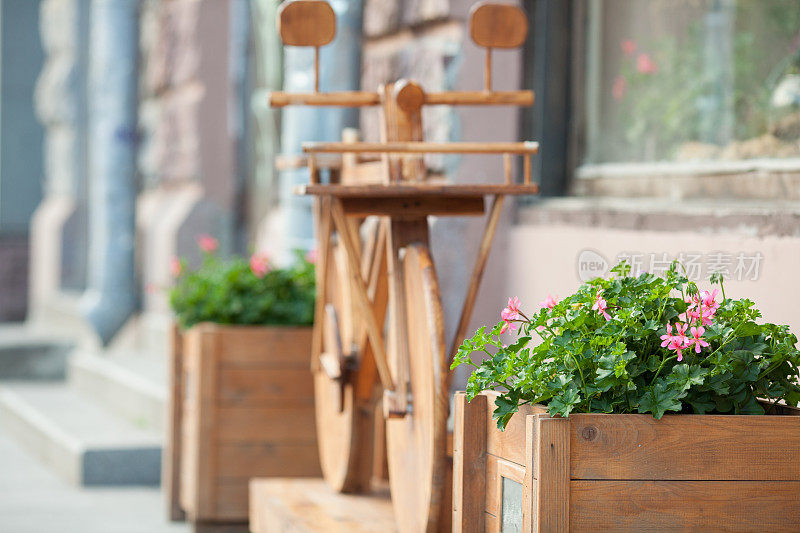 花坛上的背景是一辆木制自行车。城市的珠宝