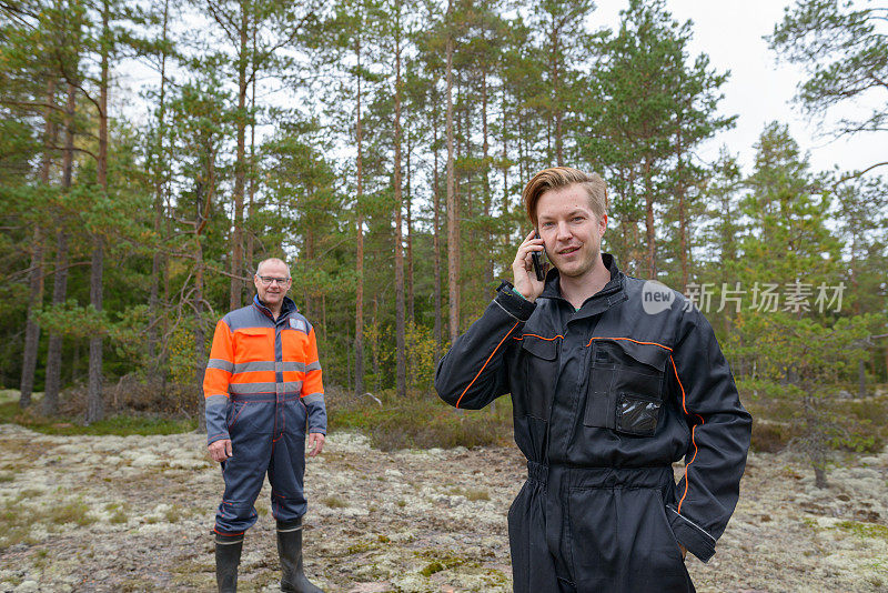 一个成熟的男人和一个年轻的男人一起在森林里工作