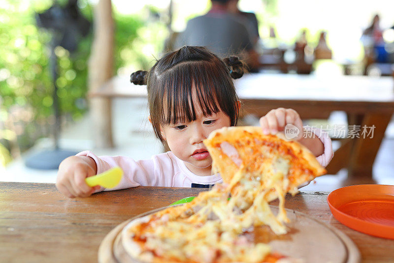 小女孩喜欢吃披萨。