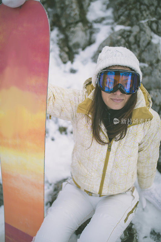 冬天穿着滑雪服的女人靠近滑雪板