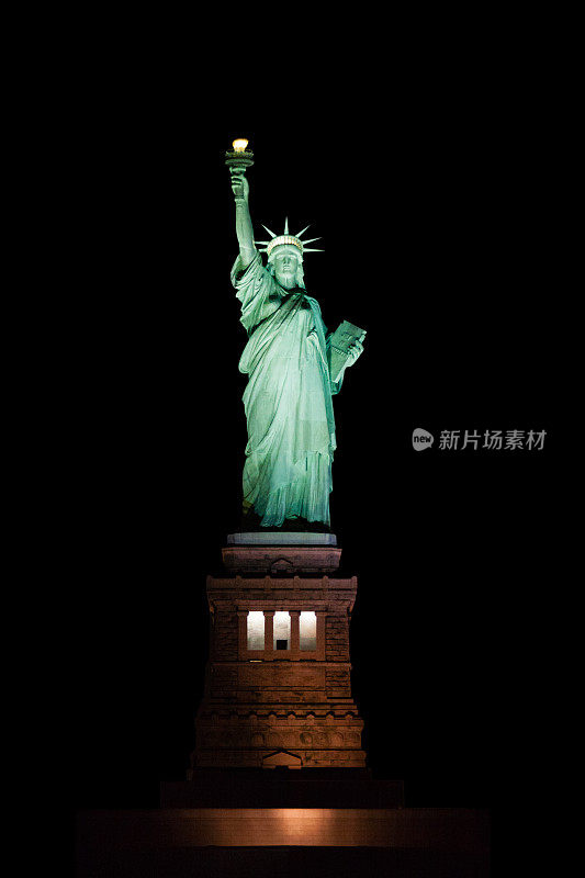 自由女神像在日落时被照亮，孤立在黑色，纽约市。