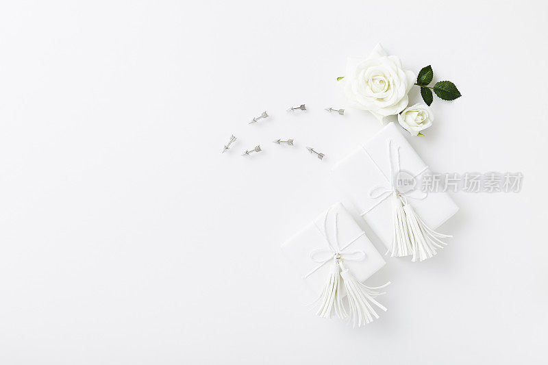 白色背景上装饰有流苏和玫瑰的结婚礼物
