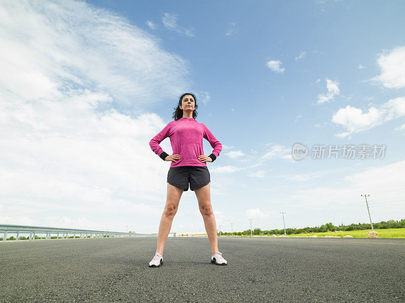 一名成年女子准备在柏油路上慢跑