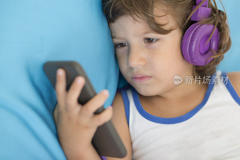可爱的小男孩一边听音乐一边放松。